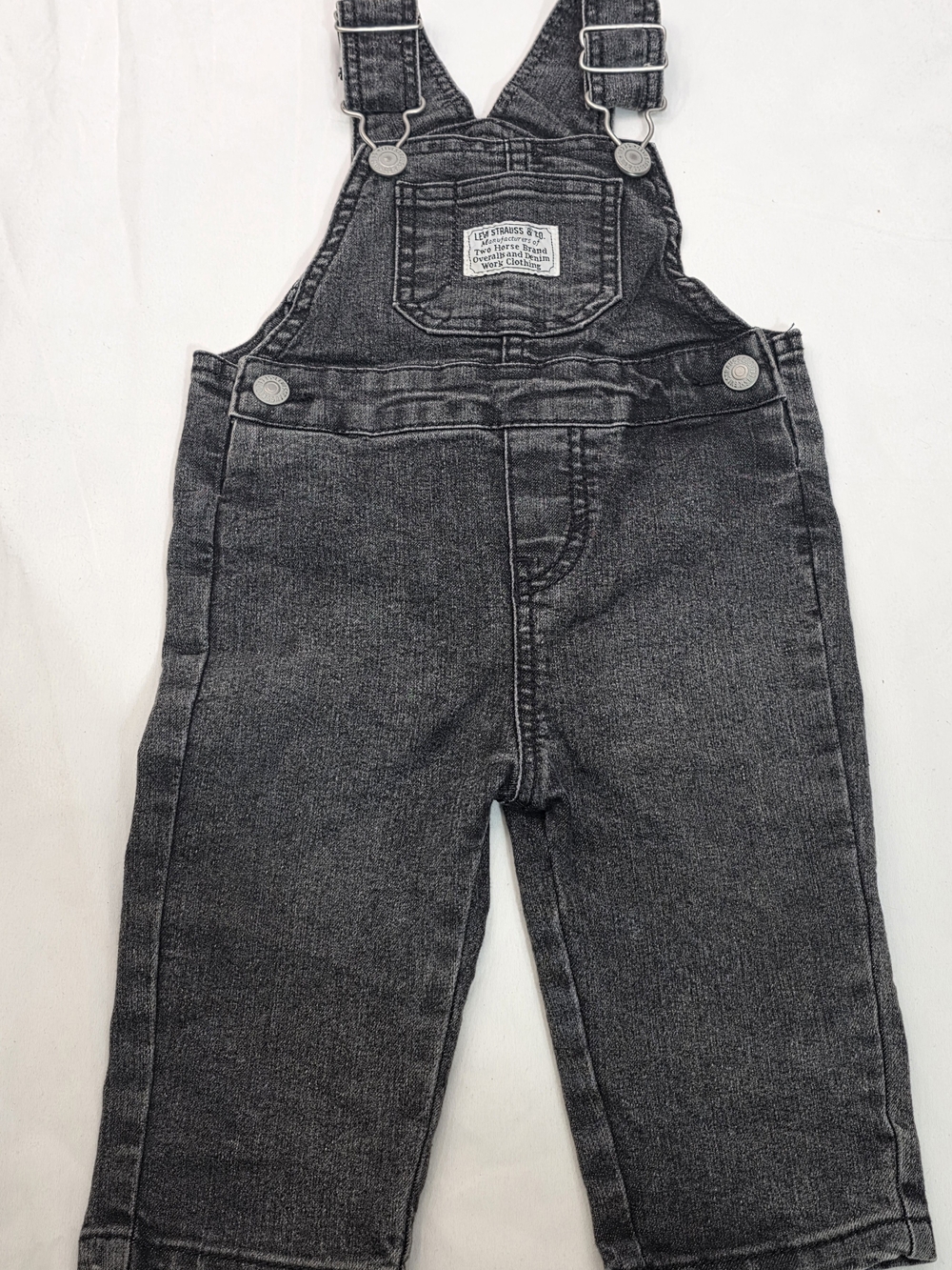 Levi's brand black denim baby overalls, which stand out for their classic patch